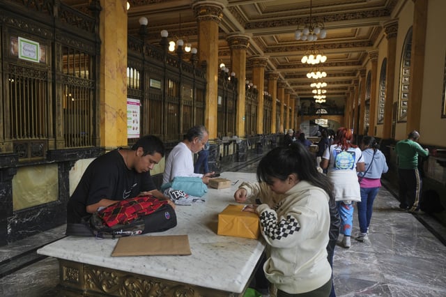 People prepare packages to send at the Main Post Office in Mexico City, Wednesday, Aug. 27, 2025.