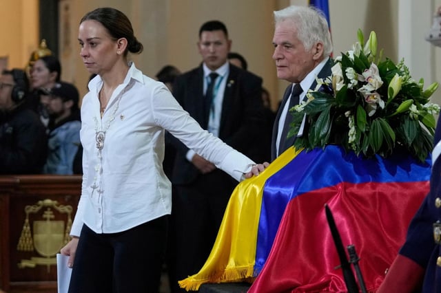 María Claudia Tarazona y Miguel Uribe, esposa y padre del aspirante presidencial y senador opositor Miguel Uribe Turbay, pasan junto a su ataúd tras hablar durante el funeral, en Bogotá, Colombia, el miércoles 13 de agosto de 2025. Uribe murió a causa de las heridas sufridas al recibir un disparo en un mitin político. (Foto AP/Fernando Vergara)