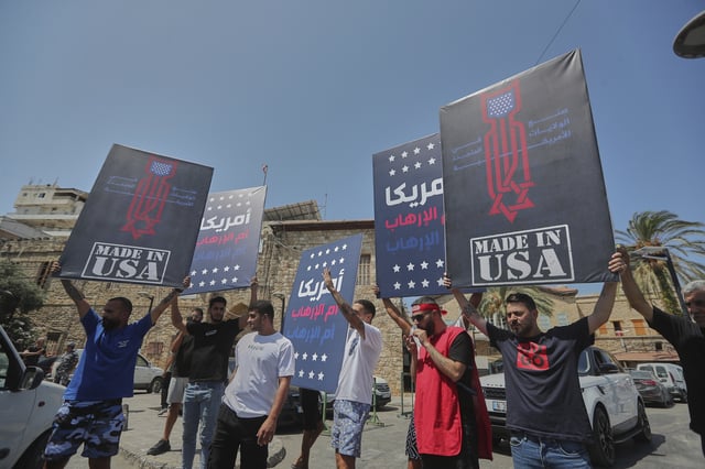Shiite men hold up posters that read in Arabic: "America is the mother of terrorism", during a protest against Tom Barrack, U.S. President Donald Trump's envoy to the Middle East, who was supposed to visit Tyre city in south Lebanon, Wednesday, Aug. 27, 2025. (AP Photo/Mohammed Zaatari)