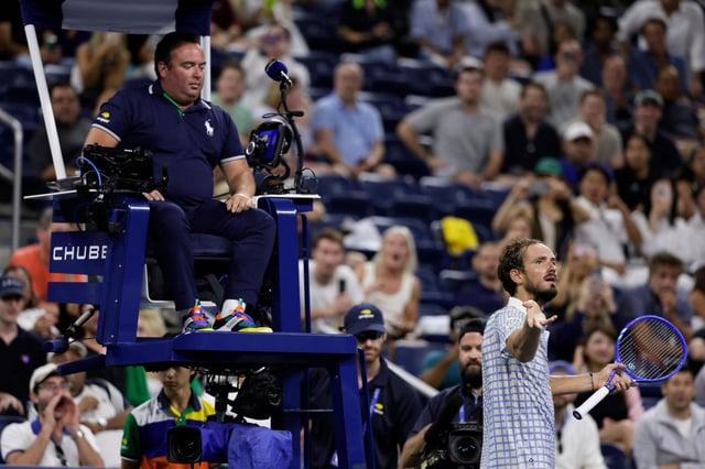 Daniil Medvedev, abajo a la derecha, de Rusia, reacciona cerca del juez de silla, Greg Allensworth, izquierda, después de que un fotógrafo corriera dentro de la cancha durante un punto en el partido contra Benjamin Bonzi, de Francia, en la primera ronda del torneo de tenis US Open, el domingo 24 de agosto de 2025, en Nueva York. (AP Foto/Adam Hunger)