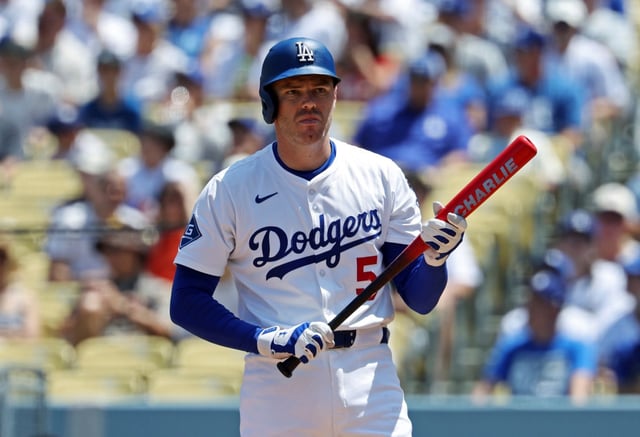 The Dodgers’ Freddie Freeman holds a bat, with his son Charlie’s name on it, before hitting a three-run home run during the first inning of a game against the San Diego Padres on Sunday, Aug. 17, 2025, at Dodger Stadium. (AP Photo/Kevork Djansezian)