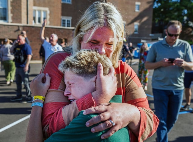 A parent hugs her son after an active shooter situation at the Annunciation Church in Minneapolis, Minn., Wednesday, Aug. 27, 2025. (Richard Tsong-Taatarii/Star Tribune via AP)