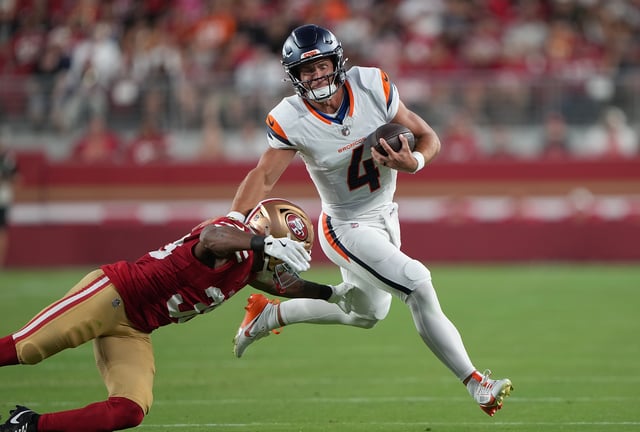 SANTA CLARA, CALIFORNIA - AUGUST 09: Sam Ehlinger #4 of the Denver Broncos scrambling with the ball fights off the tackle of Eli Apple #30 of the San Francisco 49ers in second half of an NFL Preseason 2025 game at Levi's Stadium on August 09, 2025 in Santa Clara, California. (Photo by Thearon W. Henderson/Getty Images)