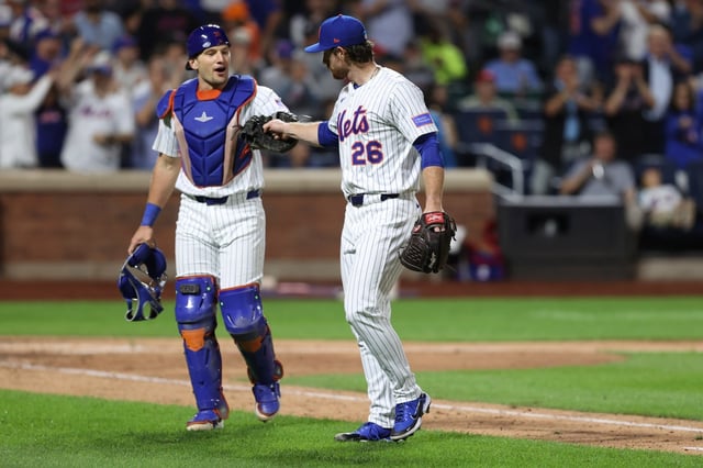 New York Mets catcher Hayden Senger, left, and pitcher Nolan McLean, right, walk to the dugout during the eighth inning of a baseball game against the Philadelphia Phillies, Wednesday, Aug. 27, 2025, in New York. (AP Photo/Pamela Smith)