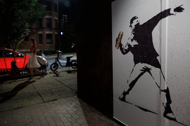 A person walks past art work depicting Sean Charles Dunn.