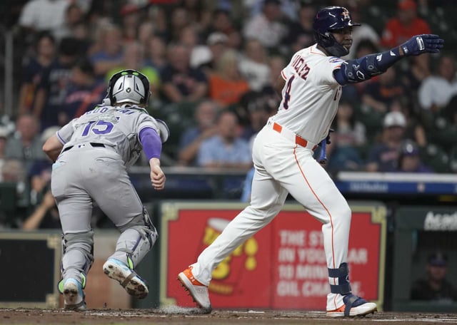 Houston Astros Jesús Sánchez (4) waves Yordan Alvarez to second base after a dropped ball by Colorado Rockies catcher Hunter Goodman during the first inning of an MLB baseball game in Houston, Wednesday, Aug. 27, 2025.