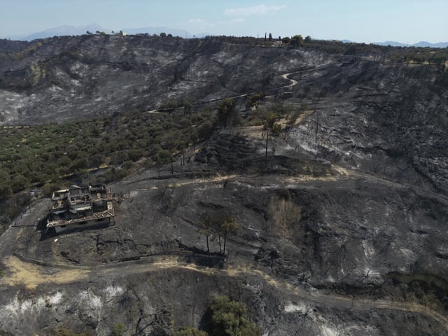 FILE - A burned house on a hill is visible from above in Kaminia seaside village, during a wildfire near Patras city, western Greece, Aug. 13, 2025. (AP Photo/Thanassis Stavrakis, File)