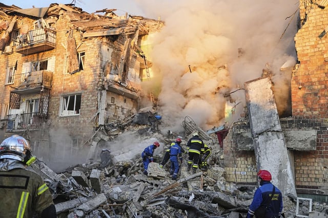 Los bomberos trabajan en el lugar donde se encuentra un edificio en llamas tras un ataque ruso en Kiev.