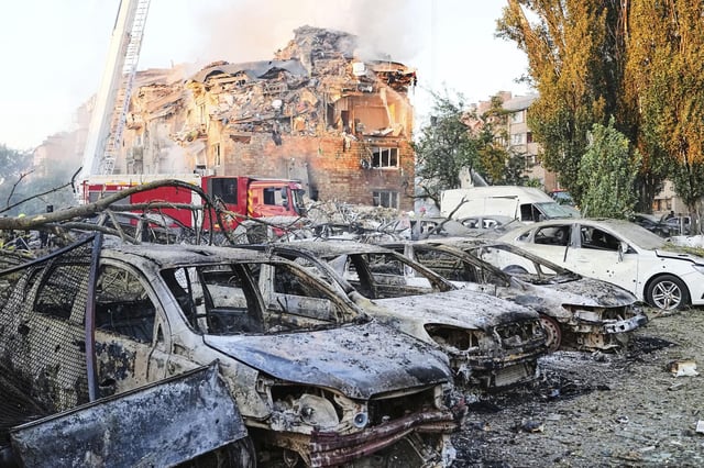 Los bomberos trabajan en el lugar donde se encuentra un edificio en llamas tras un ataque ruso en Kiev.