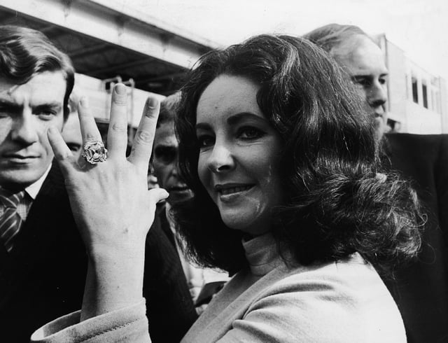 British-born actress Elizabeth Taylor shows off a 33.19 carat diamond ring, a present from her fifth husband Richard Burton.