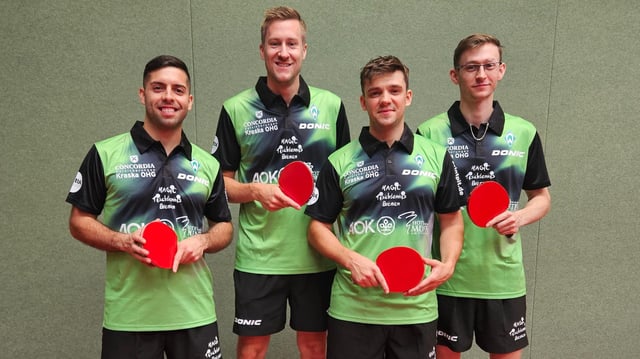 Werders Tischtennis-Mannschaft mit den Spielern Marcelo Aguirre, Mattias Falck, Kirill Gerassimenko und Irvin Bertrand stehen lächelnd mit ihren Schlägern in der Hand beim Gruppenfoto.