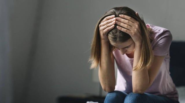 Una joven con signos de tristeza.