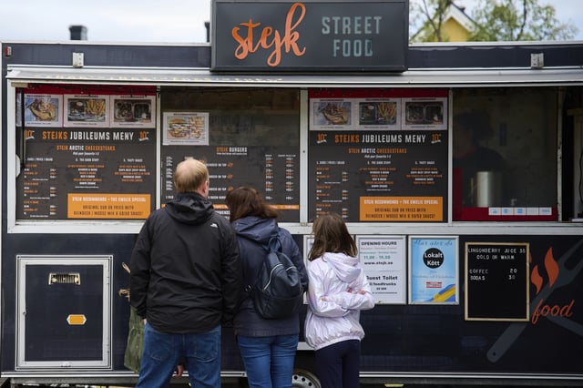 Customers look at the menus outside the Stejk Street Food truck in Kiruna, Sweden, Sunday, Aug. 17, 2025. (AP Photo/Malin Haarala)