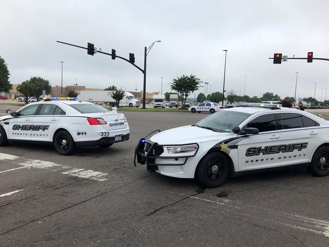 Police officers stand outside a Walmart store, Tuesday, July 30, 2019, in Southaven, Miss. Officials say two people are dead and a police officer and a suspect were shot at the Walmart in the northern Mississippi city town, a suburb of Memphis, Tennessee. (AP Photo/Adrian Sainz)