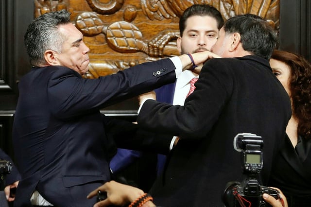 Senator Alejandro Moreno (L) of the minority PRI party scuffles with Senator Gerardo Fernandez Norona as they came to blows following a heated debate over alleged calls from the opposition for the United States to intervene militarily against drug cartels