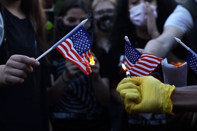 Anti-Trump activists burn U.S. flags near the White House on July 4, 2020, in Washington, DC.