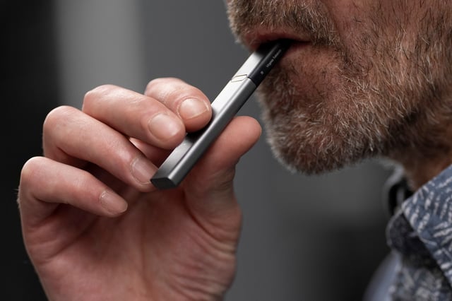 A person holds a disposable vape as he poses for a photograph near London Bridge in London, Britain, May 30, 2025. REUTERS/Carlos Jasso/File Photo