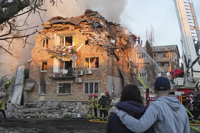 Firefighters work at the site of a burning building after a Russian attack in Kyiv, Ukraine, early Thursday, Aug. 28, 2025.