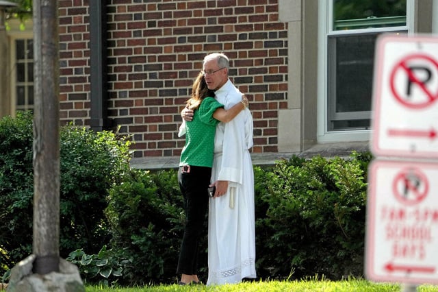 Après l'attaque et les meurtres de Robin Westman, 23 ans, dans une église catholique ce mercredi 27 août, des membres de l'Église se prennent dans les bras.
