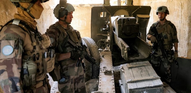 Des Casques bleus de la Force intérimaire des Nations unies au Liban (Finul) se tiennent près d’un canon d’artillerie dans une position auparavant tenue par le mouvement pro-iranien Hezbollah, dans la vallée de Khraibeh à el-Meri, dans le sud du Liban, le 27 août 2025
