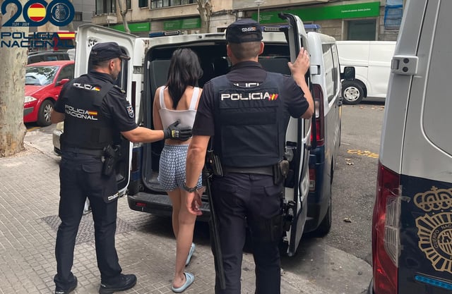 Dos agentes de la Policía Nacional, este jueves por la mañana, con la mujer detenida en Palma.