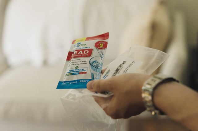 A Chicago resident holds a lead water test kit from the city.
