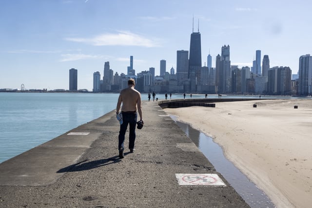 A man walks the shoreline Lake Michigan at North Avenue Beach on March 9, 2025 in Chicago, Illinois.