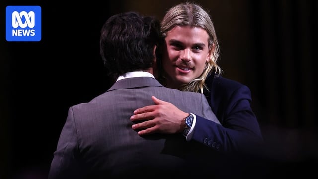 Bailey Smith hugging another man while accpeting an award