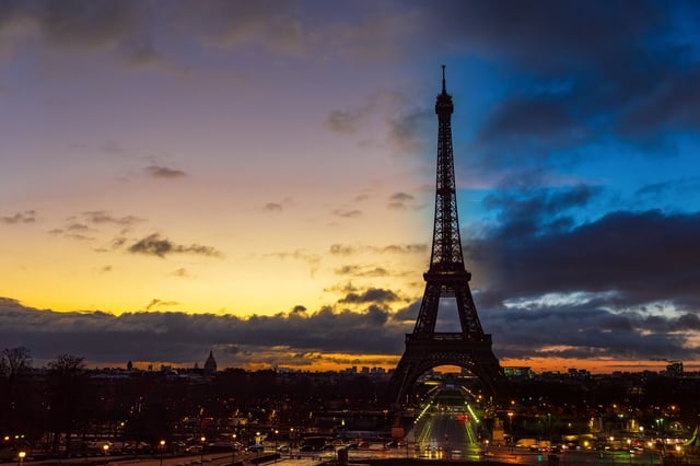 Night to Day transition over Eiffel tower in winter from Trocadero on a cloudy day - Paris, France.