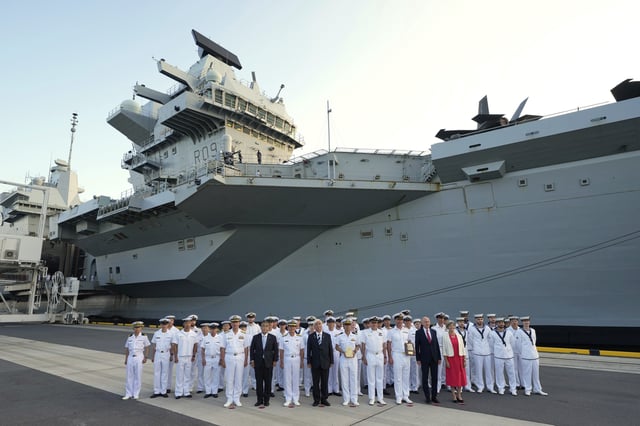 Guests and crews of the Royal Navy aircraft carrier HMS Prince of Wales pose for a group photo during its port call in Tokyo Thursday, Aug. 28, 2025. (AP Photo/Eugene Hoshiko)