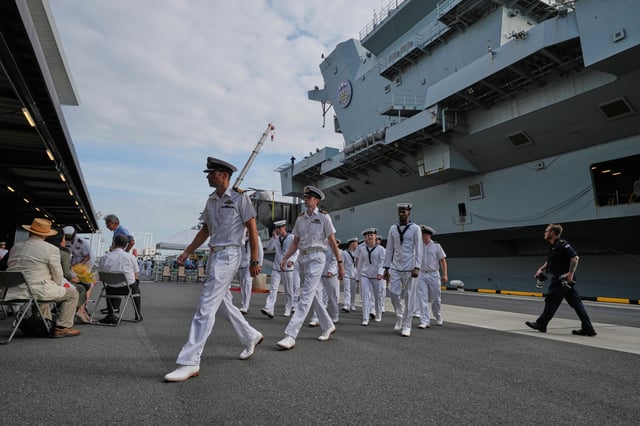 Crews walk near the Royal Navy aircraft carrier HMS Prince of Wales before its port call in Tokyo Thursday, Aug. 28, 2025. (AP Photo/Eugene Hoshiko)
