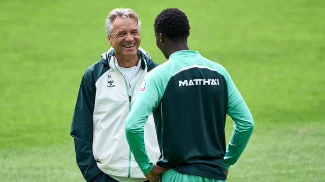 Werders Trainer Horst Steffen unterhält sich mit einem seiner Spieler und lacht.