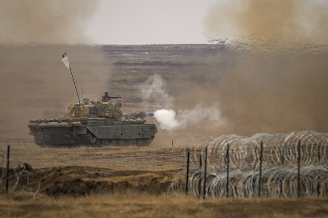 FILE - A tank fires during the Steadfast Dart 2025 exercise, involving multiple nations and representing one of the largest NATO operations planned this year, at a training range in Smardan, eastern Romania, Feb. 19, 2025. (AP Photo/Vadim Ghirda, File)
