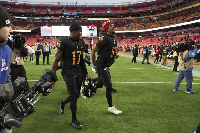 Jayden Daniels #5 of the Washington Commanders walks off the field with Terry McLaurin #17 after a game against the Tennessee Titans at Northwest Stadium on December 01, 2024 in Landover, Maryland. The Commanders defeated the Titans 42-19.