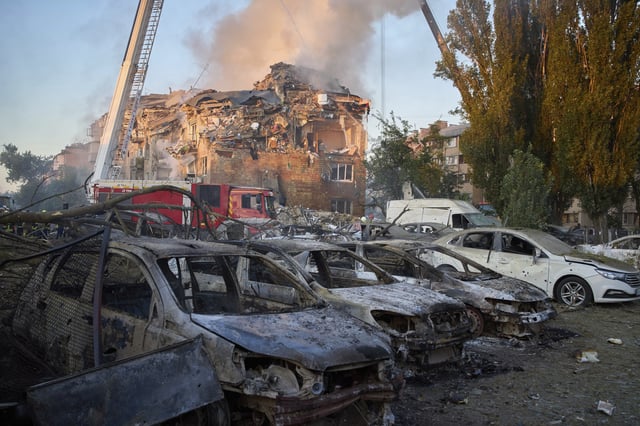 Cars are seen damaged in front of a destroyed residential building after a Russian missile attack in Kyiv, Ukraine, Thursday, Aug. 28, 2025. (AP Photo/Efrem Lukatsky)