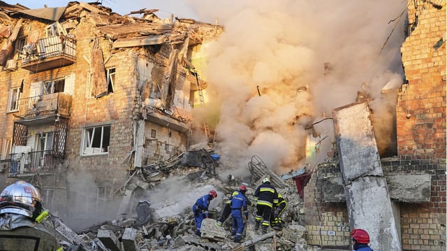 Feuerwehrleute arbeiten an einem brennende Gebäude in Kiew, Ukraine. 