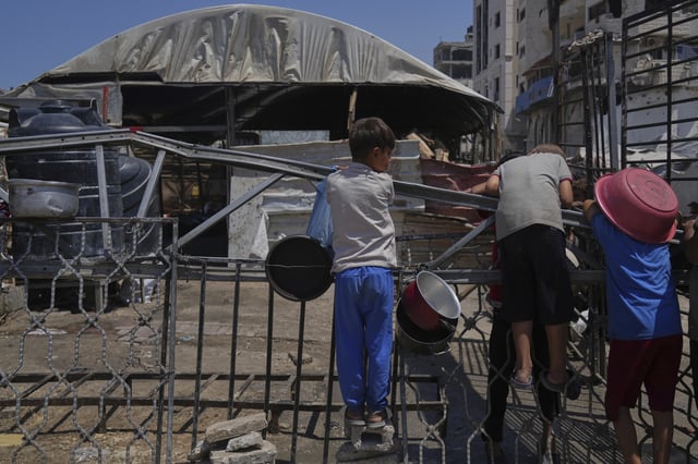 A Palestinian children wait at a community kitchen before donated food is prepared and distributed in Gaza City, Friday, Aug. 22, 2025. (AP Photo/Abdel Kareem Hana)