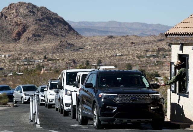 A National Park Service park ranger assists a visitor at an entrance gate to Joshua Tree National Park on February 20, 2025 near Joshua Tree, California.