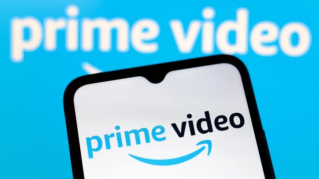The Amazon Prime Video logo appears on the screen of a smartphone and in the background on the computer screen in Reno, United States, on December 15, 2024.