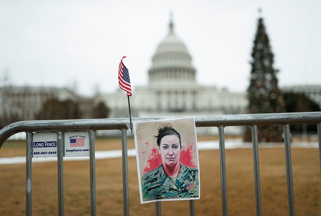A poster of Ashli Babbitt, who was killed by Capitol Police during the January 6, 2021 attack on the US Capitol, hangs on a fence on the first anniversary of the event outside the Capitol, in Washington, DC, on January 6, 2022.