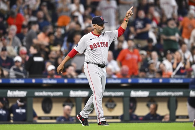 HOUSTON, TEXAS - AUGUST 21: Alex Cora #13 of the Boston Red Sox walks out to the mound for a pitching change in the seventh inning against the Houston Astros at Minute Maid Park on August 21, 2024 in Houston, Texas.