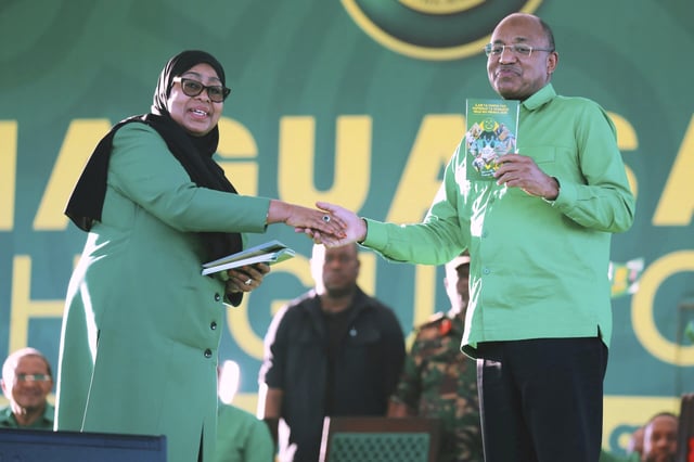 Tanzania's President Samia Suluhu Hassan, the presidential candidate of the ruling Chama Cha Mapinduzi (CCM) party, shakes hands with the President of Zanzibar, Dr. Hussein Ali Mwinyi, during the launch of the party's campaign for the upcoming general elections, at Tanganyika Packers grounds in Dar es Salaam, Tanzania, Thursday, Aug. 28, 2025. (AP Photo/Steven Genya)