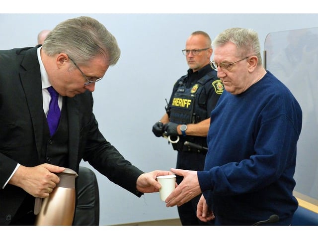  Defence lawyer Mark Gruchy (left) hands Tony Humby a glass of water as Humby’s provincial court trial gets underway in St. John’s, Aug. 27, 2025.