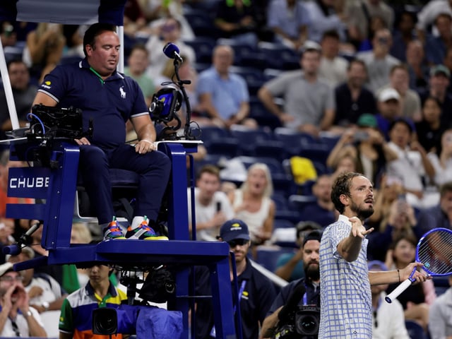 Daniil Medvedev, of Russia, bottom right, reacts next to chair umpire, Greg Allensworth, left, after a photographer ran onto the court during a match against Benjamin Bonzi, of France, in the first-round of the U.S. Open tennis championships, Sunday, Aug. 24, 2025, in New York. (AP Photo/Adam Hunger)