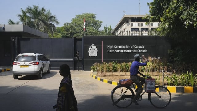 A cyclist pedals past the Canadian High Commission in New Delhi, India, Tuesday, Oct. 15, 2024. (AP Photo/Manish Swarup)