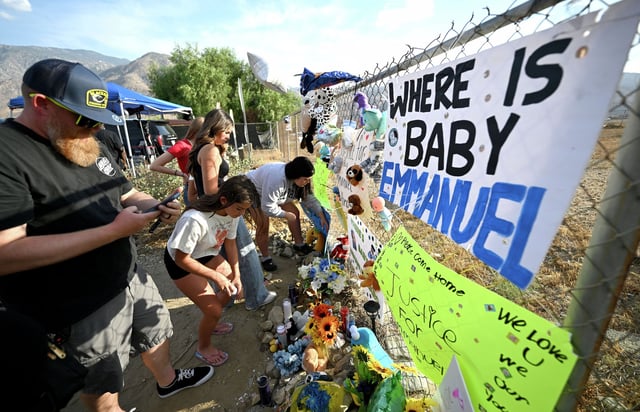 Visitors gather around a makeshift memorial prior to a vigil for missing 7-month-old Emmanuel Haro outside the child’s Cabazon home on Friday, Aug. 22, 2025. The child’s parents Rebecca and Jake Haro were arrested Friday morning on suspicion of murder.