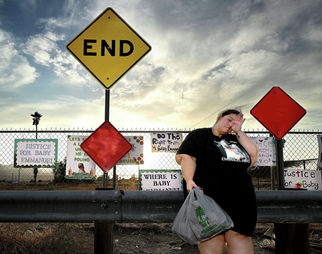 Arcelia Sanchez-Turner, from Banning, wipes her eyes at a makeshift memorial prior to a vigil for missing 7-month-old Emmanuel Haro outside the child’s Cabazon home on Friday, Aug. 22, 2025. The child’s parents Rebecca and Jake Haro were arrested Friday morning on suspicion of murder. 