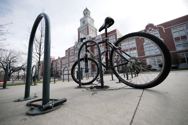 FILE - A bicycle stands in the rack outside East High School, April 17, 2019, in Denver. (AP Photo/David Zalubowski, File)