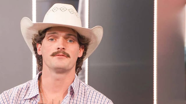 A man with a mustache and cowboy hat looking dopey