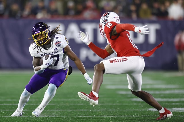 Rahjai Harris #47 of the East Carolina Pirates rushes the ball past Devon Marshall #16 of the North Carolina State Wolfpack during the Go Bowling Military Bowl at Navy-Marine Corps Memorial Stadium on December 28, 2024 in Annapolis, Maryland.